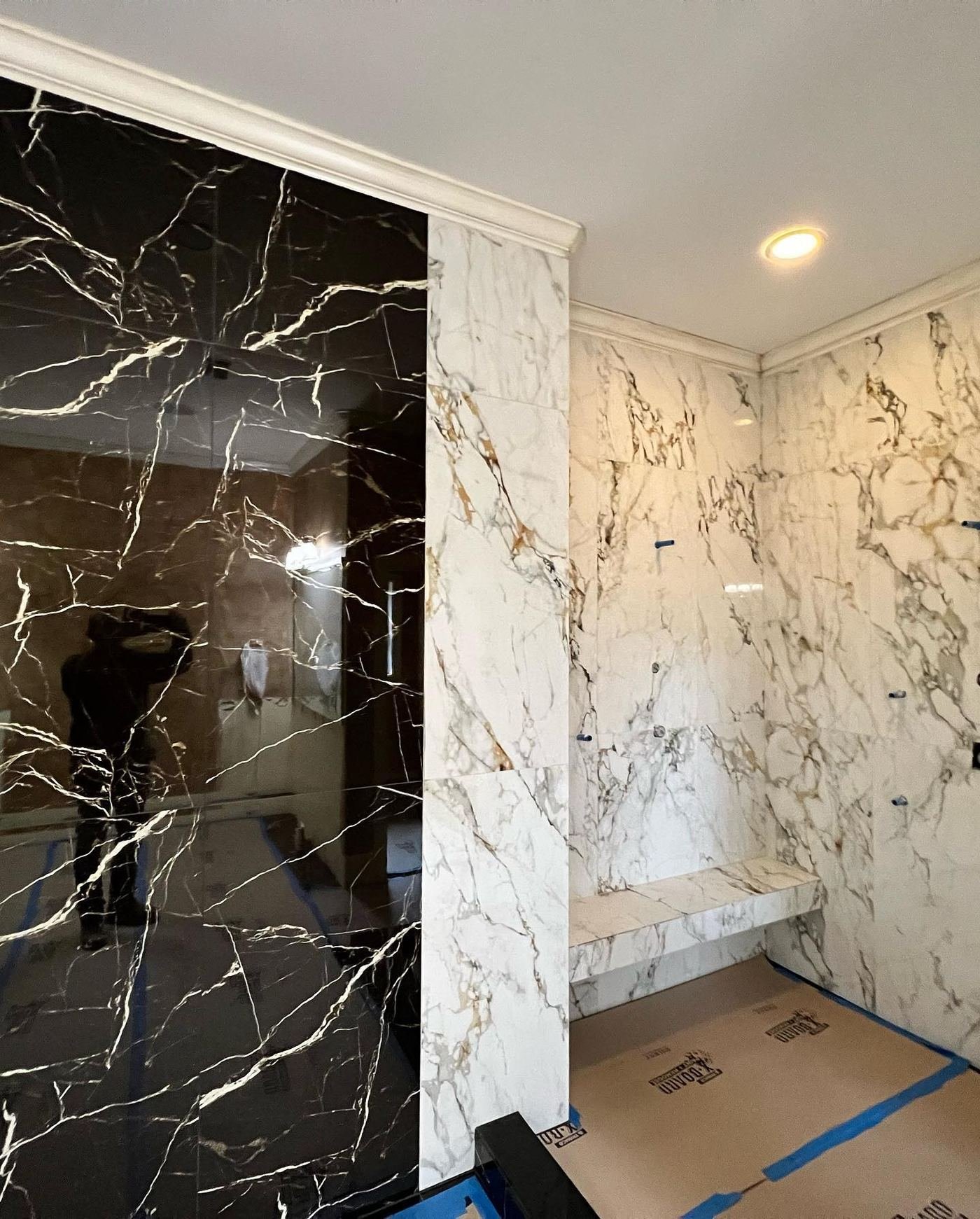 Black marble and white marble slab walls framing a doorway in a large-format porcelain installation