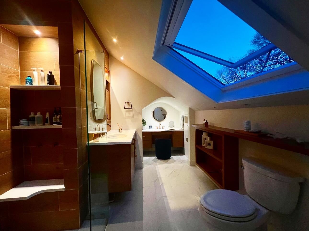 Wood-clad bathroom with a skylight, custom vanity and soaking tub