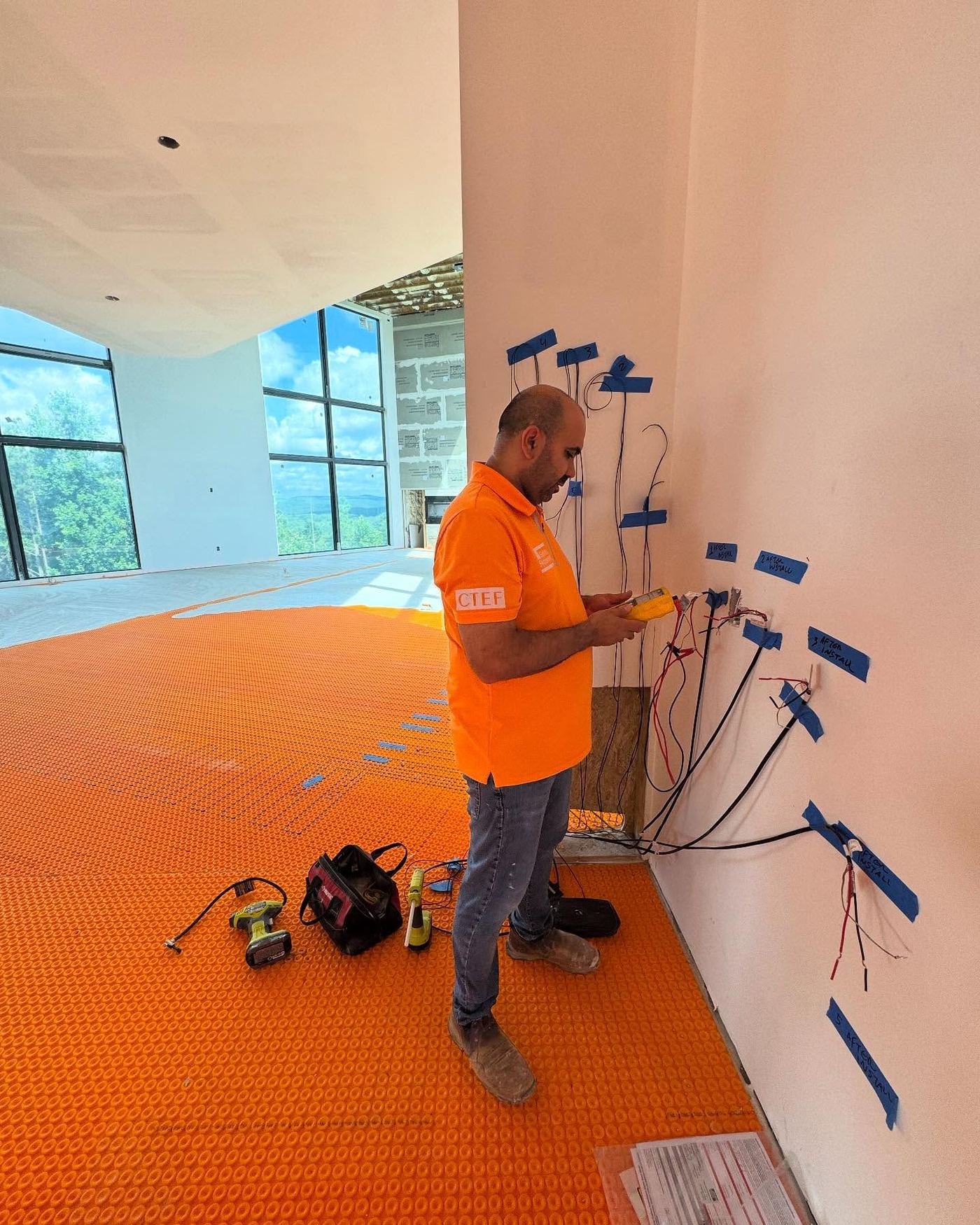 Installer laying Schluter Ditra-Heat cable over uncoupling membrane