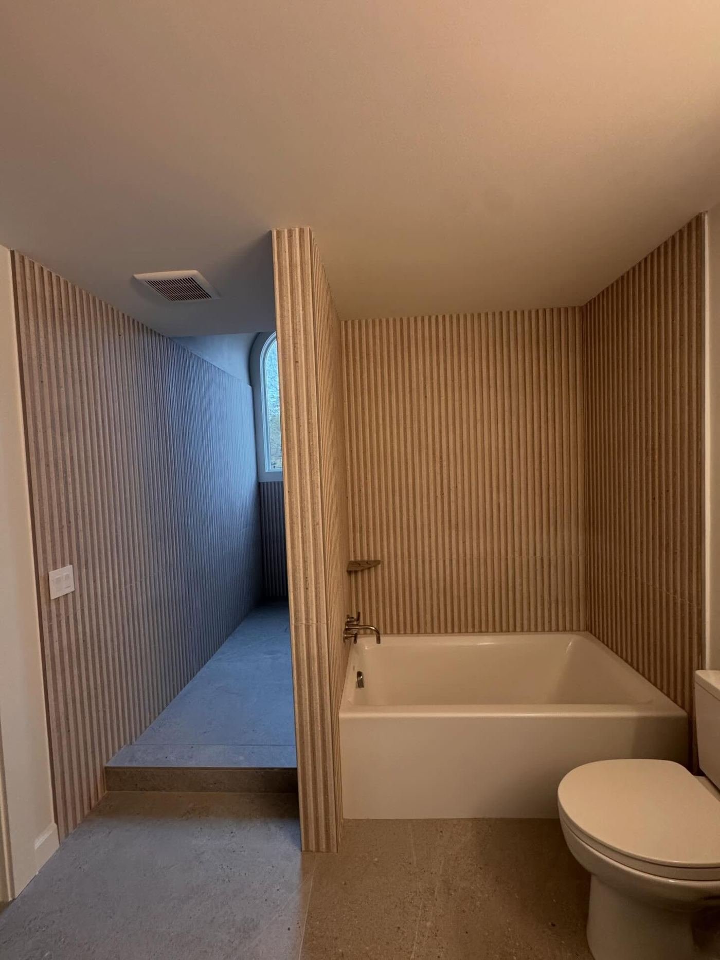 Alcove tub surround finished in vertical fluted tile