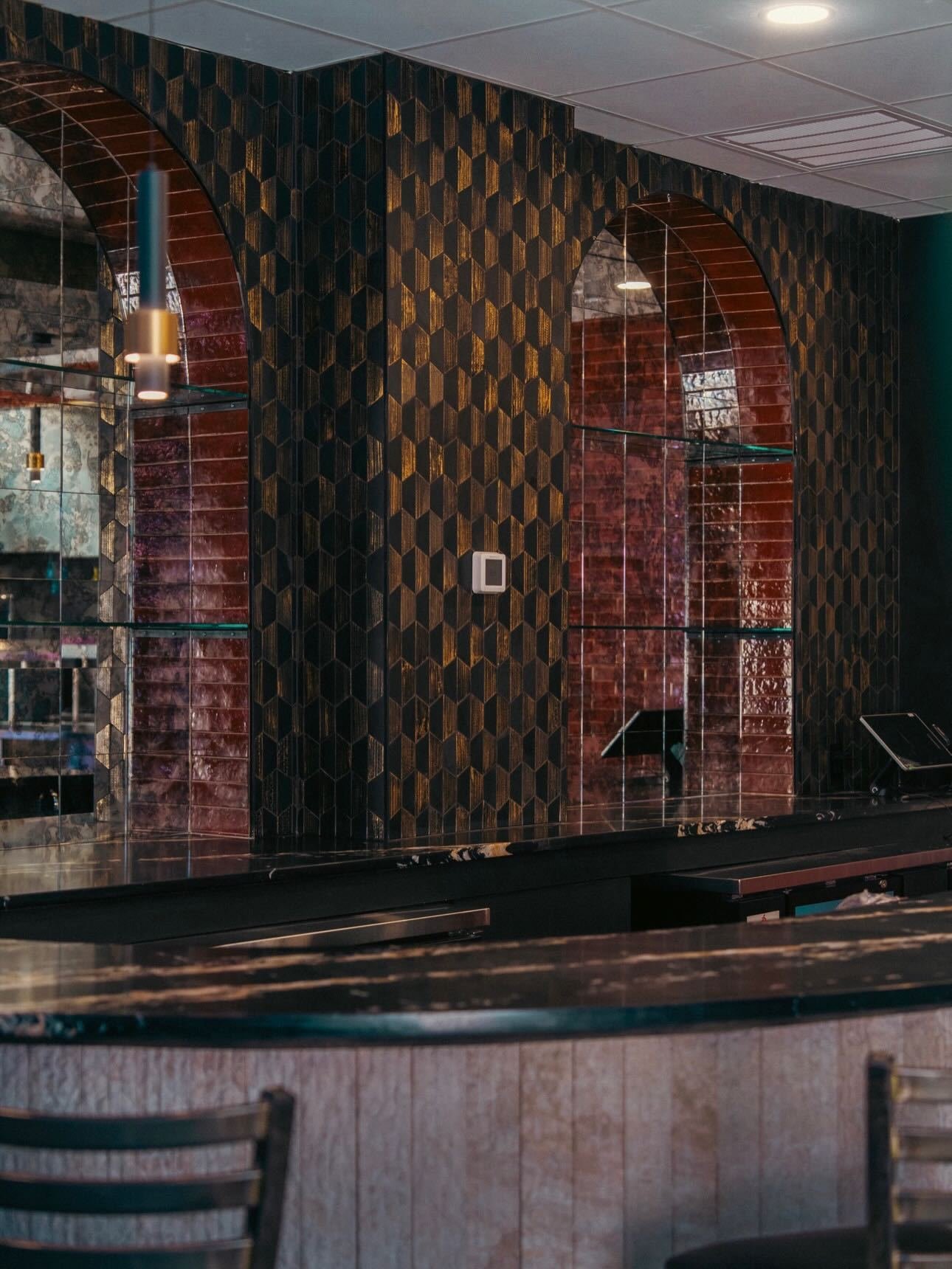 Commercial bar with a textured green and copper tile feature wall